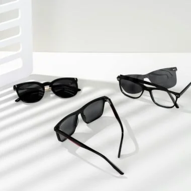 Array of stylish sunglasses on a white background with artistic shadows.